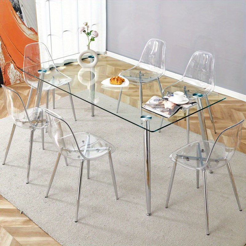 Table and chair set.Modern rectangular glass dining table with tempered glass countertop and silver metal legs, paired with multiple transparent high-quality PET dining chairs with silver legs.