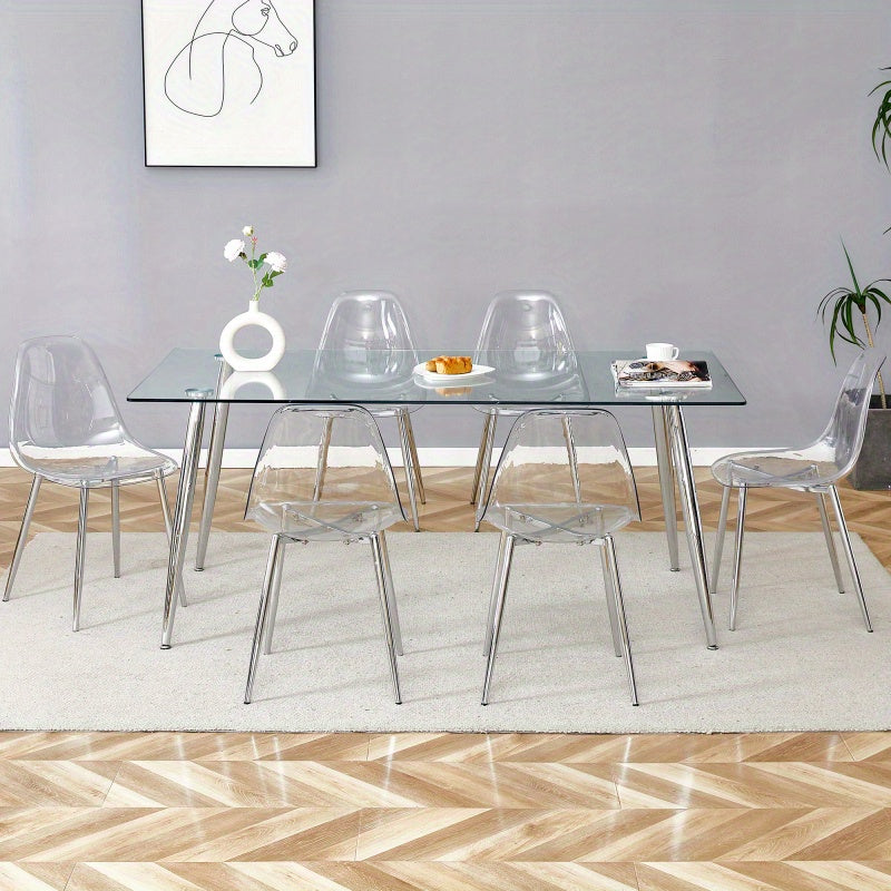 Table and chair set.Modern rectangular glass dining table with tempered glass countertop and silver metal legs, paired with multiple transparent high-quality PET dining chairs with silver legs.