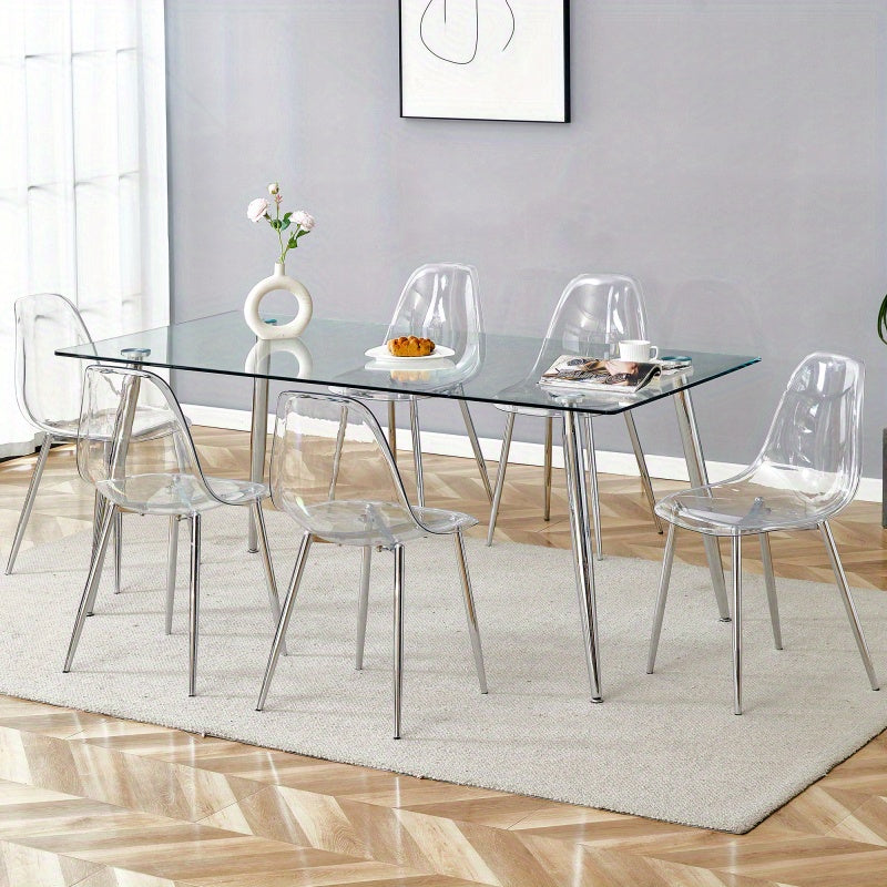 Table and chair set.Modern rectangular glass dining table with tempered glass countertop and silver metal legs, paired with multiple transparent high-quality PET dining chairs with silver legs.